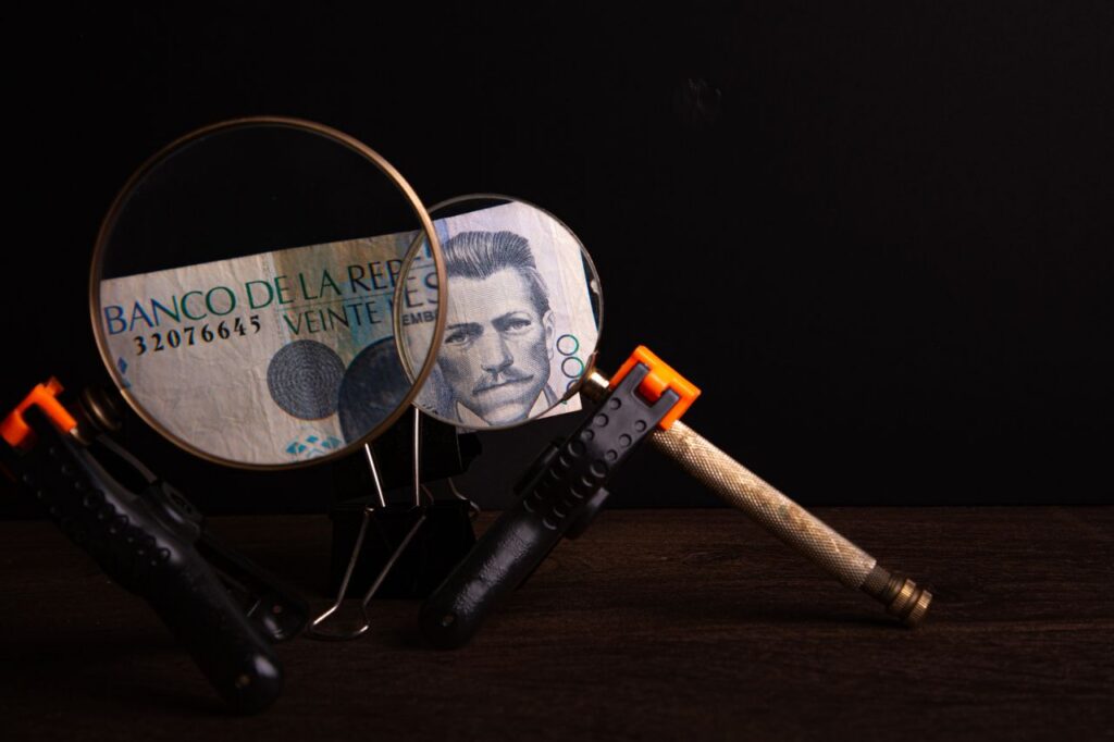 Acceso a la información pública Magnifying glasses highlighting details on a Banco de la República note in a creative setup.